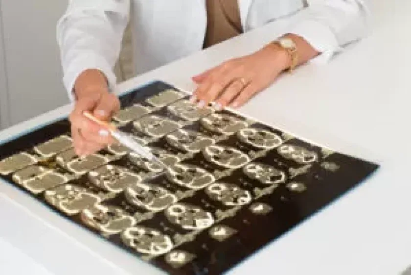Dra. Maximiana apontando para bandeja de implantes dentários